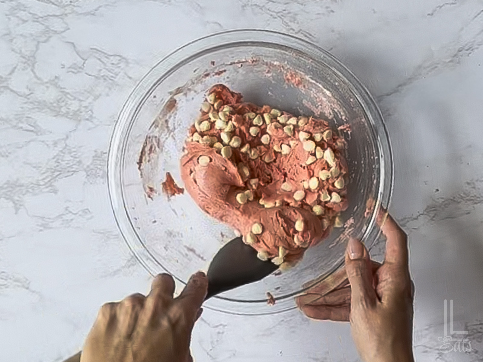 folding white chocolate chips into the cookie dough.