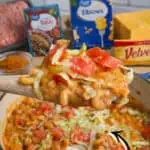 Delicious one-pot taco mac and cheese with toppings in a blue skillet.