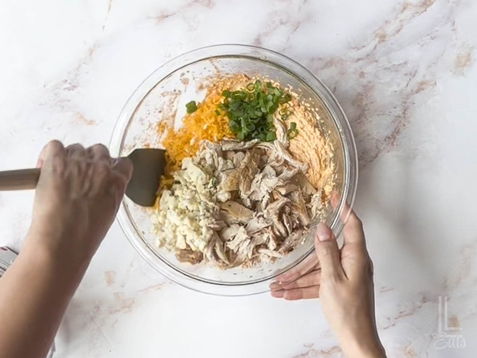 hand-stirring chicken, blue cheese, cheddar cheese, and green onions into cream cheese mixture.