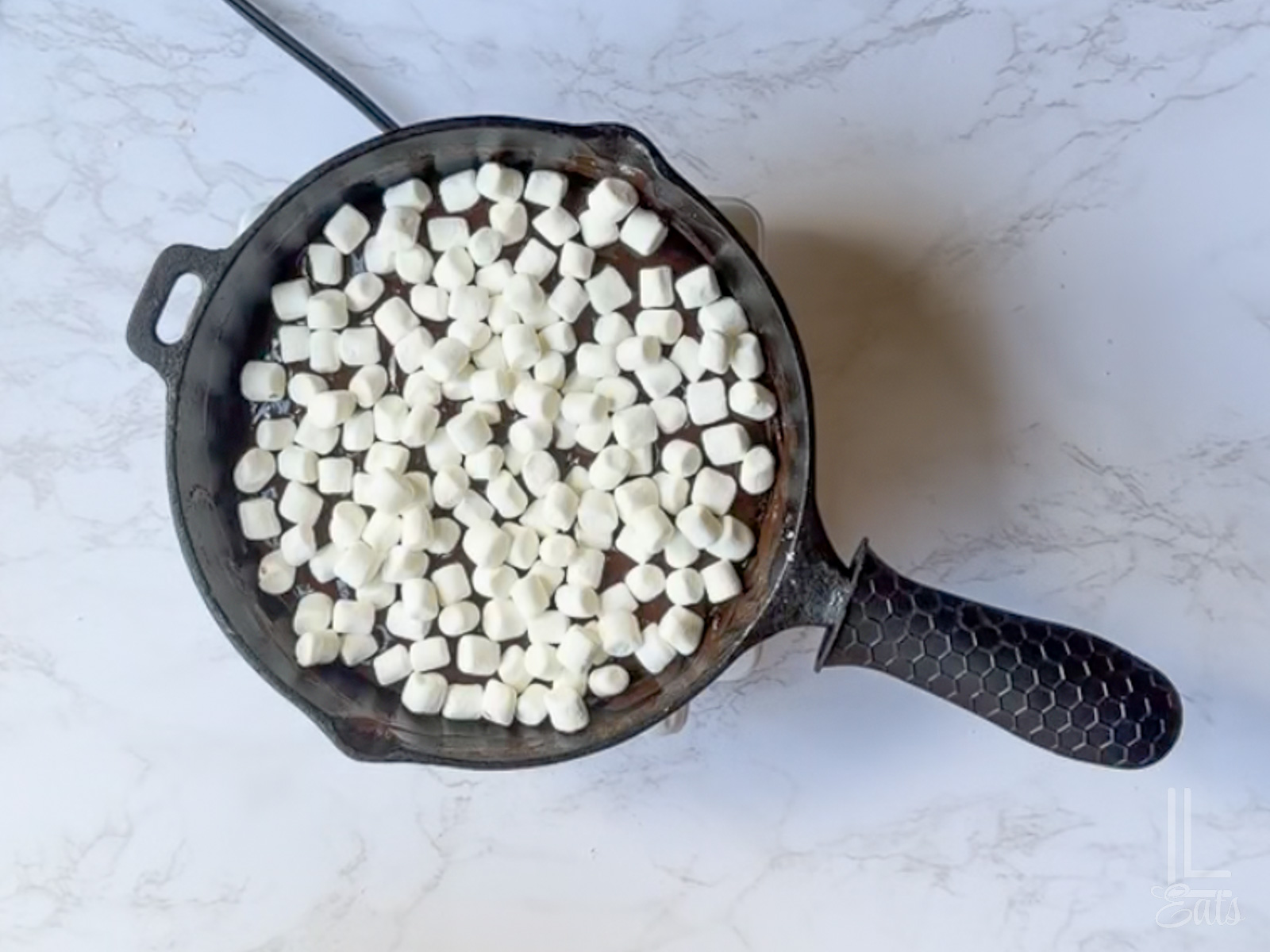 added marshmallows on top of the chocolate mixture in the skillet.