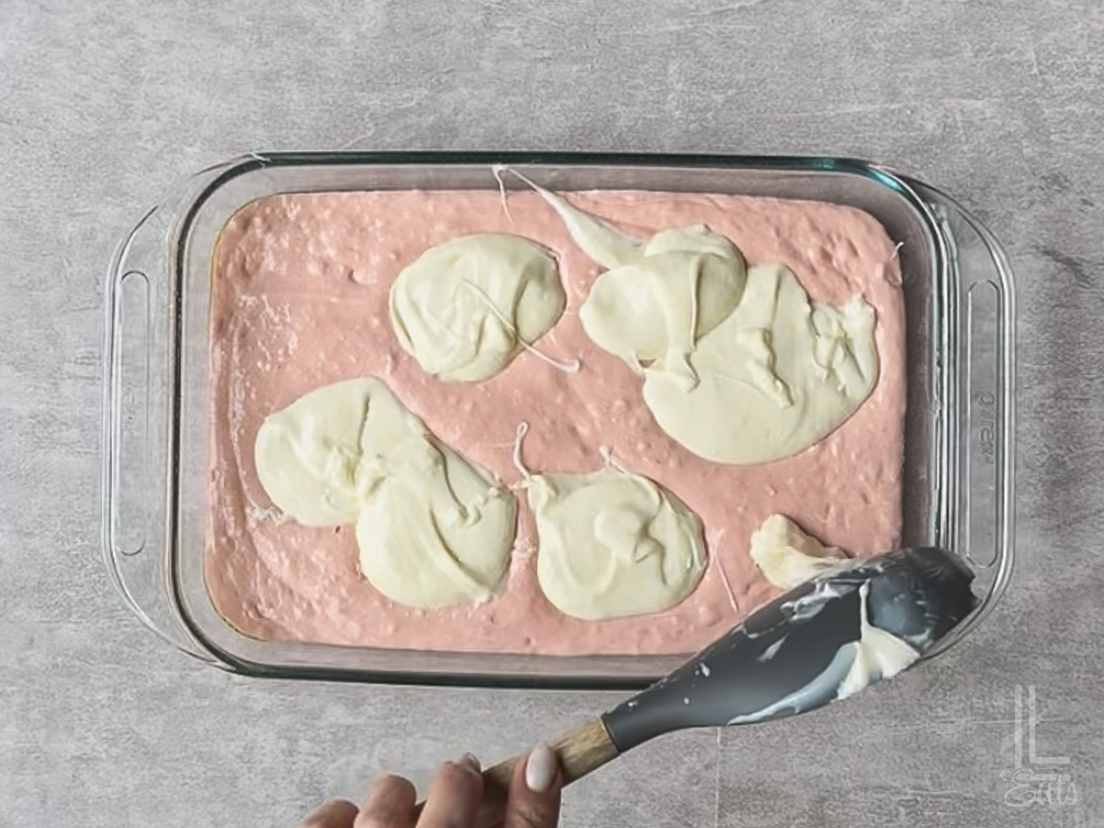 spooning dollops of cream cheese mixture over cake batter in the pan.