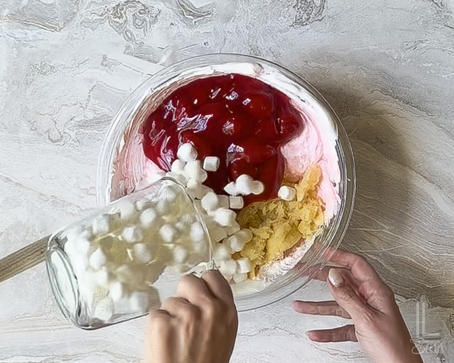 adding strawberry pie filling, marshmallows, and crushed pineapple to the strawberry fluff salad.