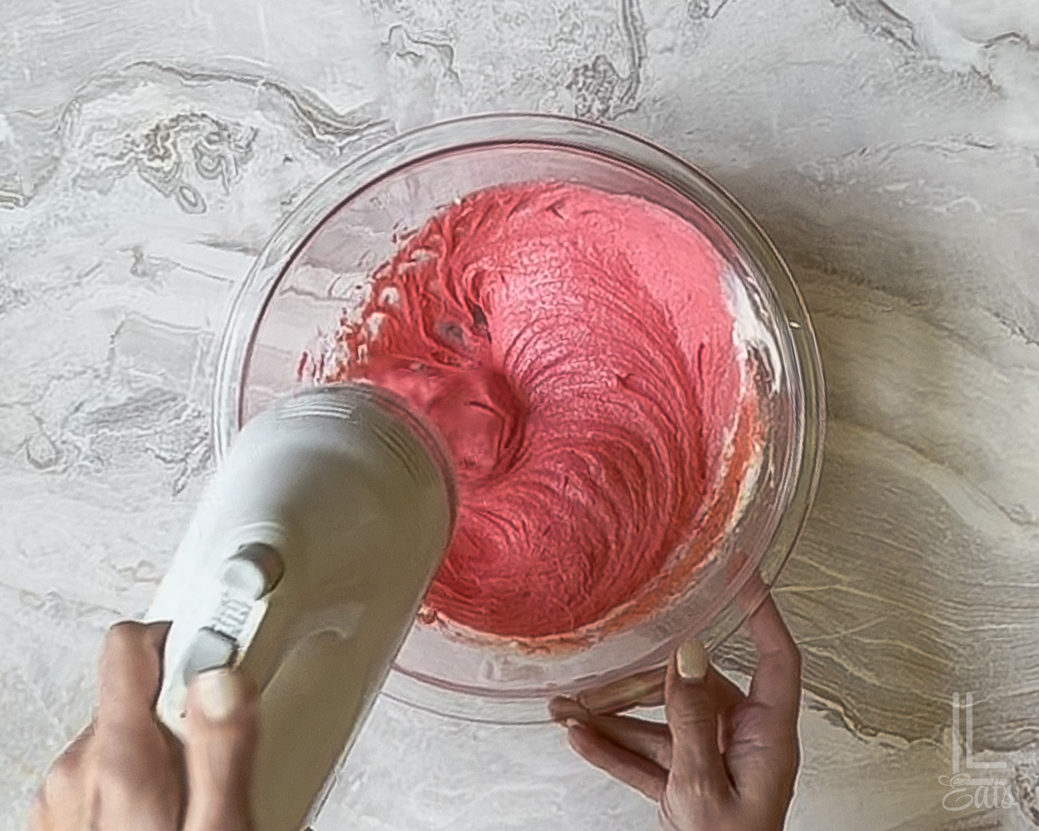 beating strawberry jello powder into the cream cheese mixture with a hand mixer.