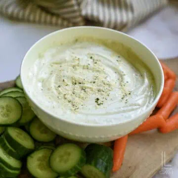 cottage cheese ranch dip in a bowl, surrounded by cut veggies.