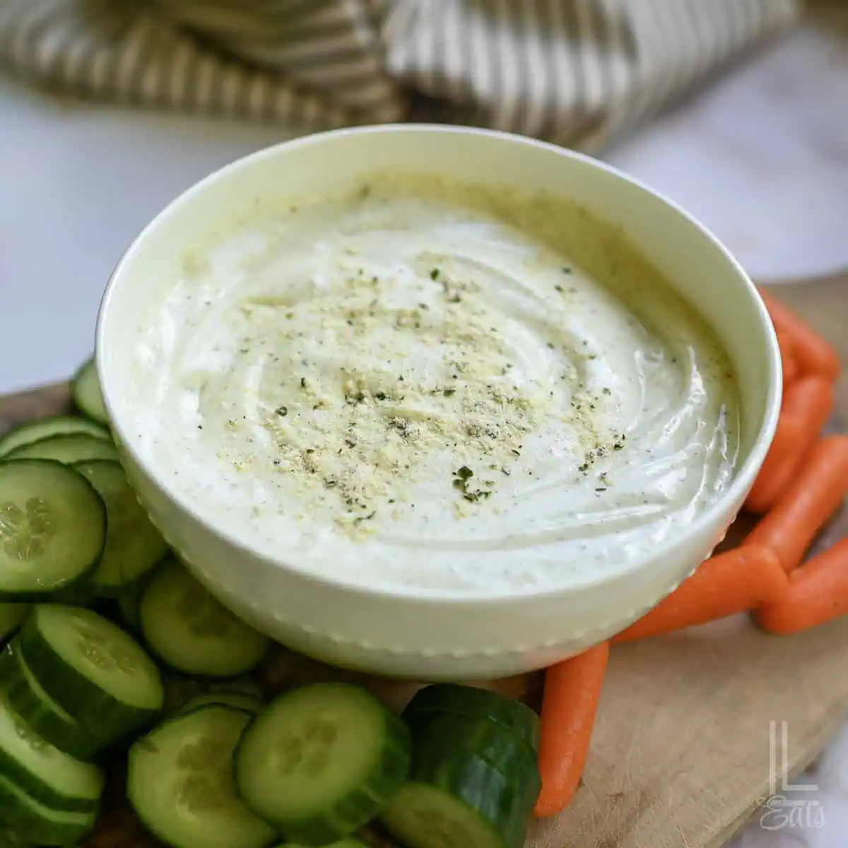 cottage cheese ranch dip in a bowl, surrounded by cut veggies.