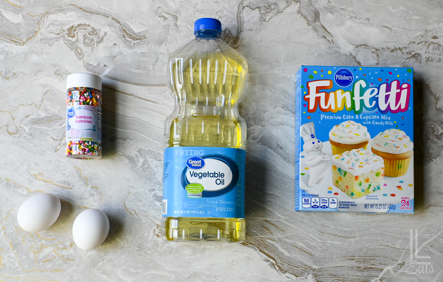 ingredients for funfetti cake mix cookies (eggs, cake mix, vegetable oil, and sprinkles).