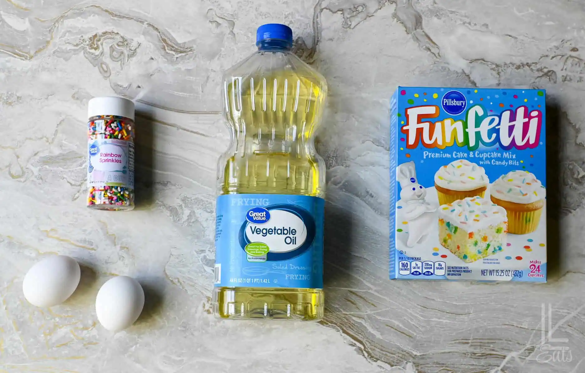 ingredients for funfetti cake mix cookies (eggs, cake mix, vegetable oil, and sprinkles).