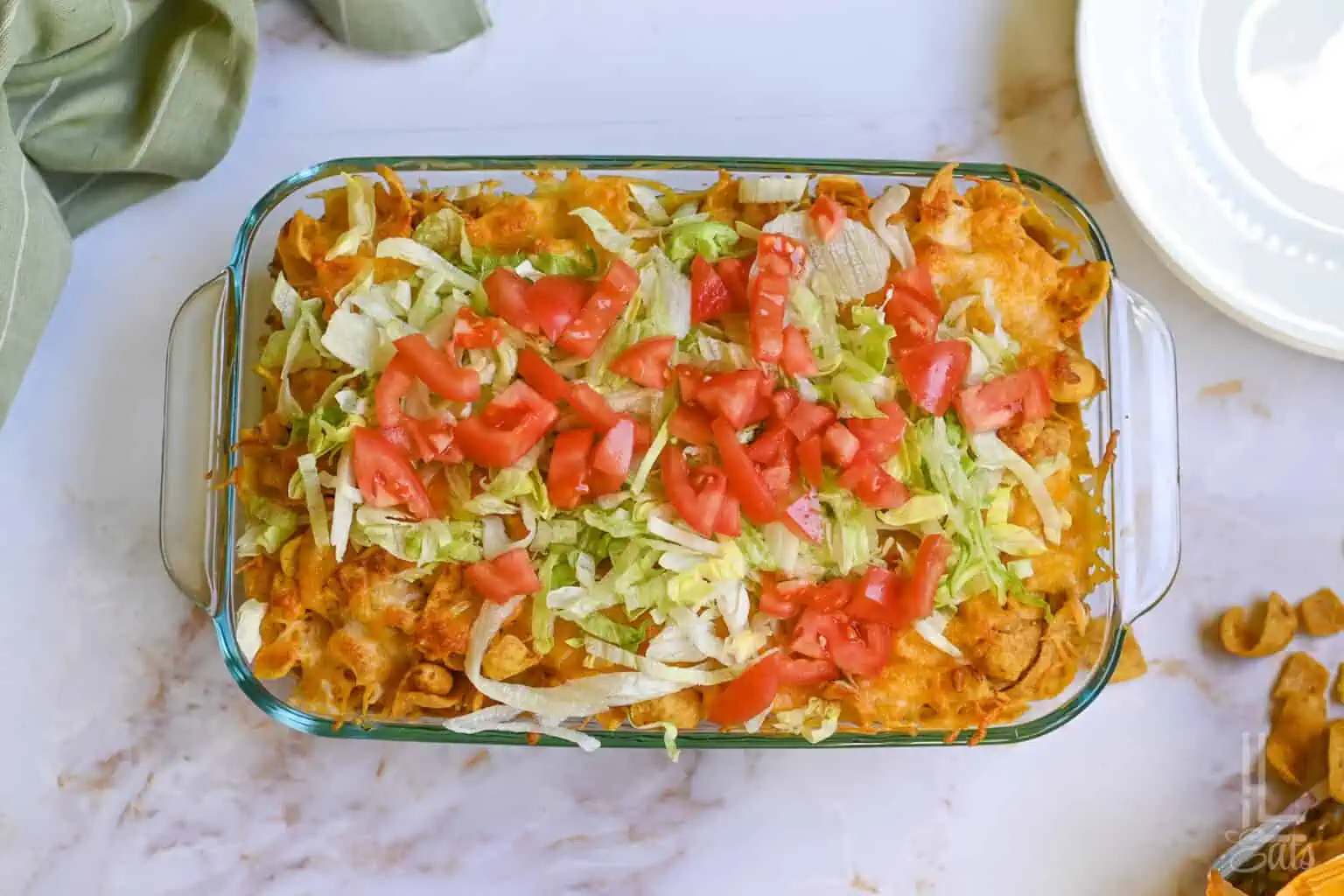 walking taco casserole, covered in shredded lettuce and diced tomato.