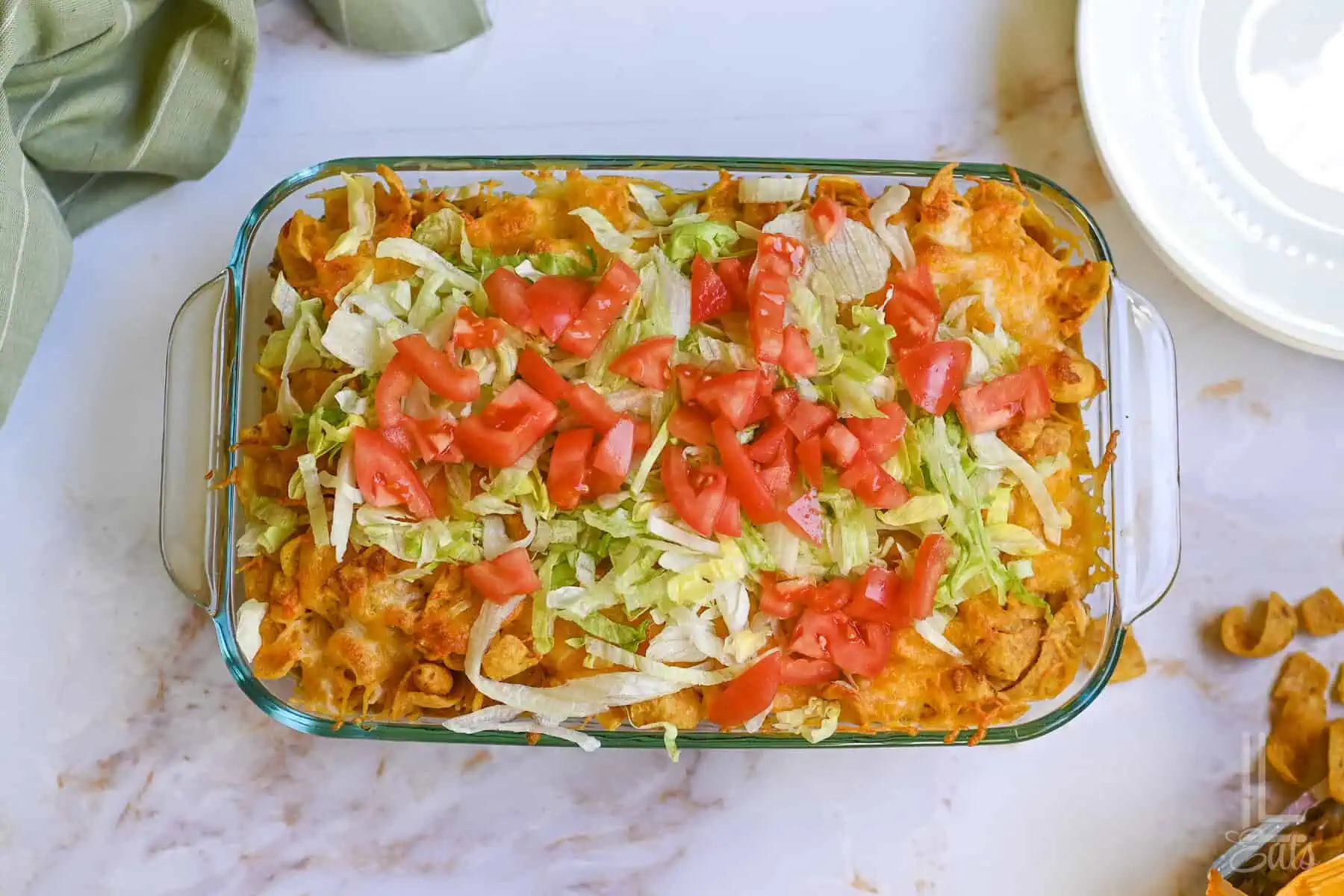 walking taco casserole, covered in shredded lettuce and diced tomato.