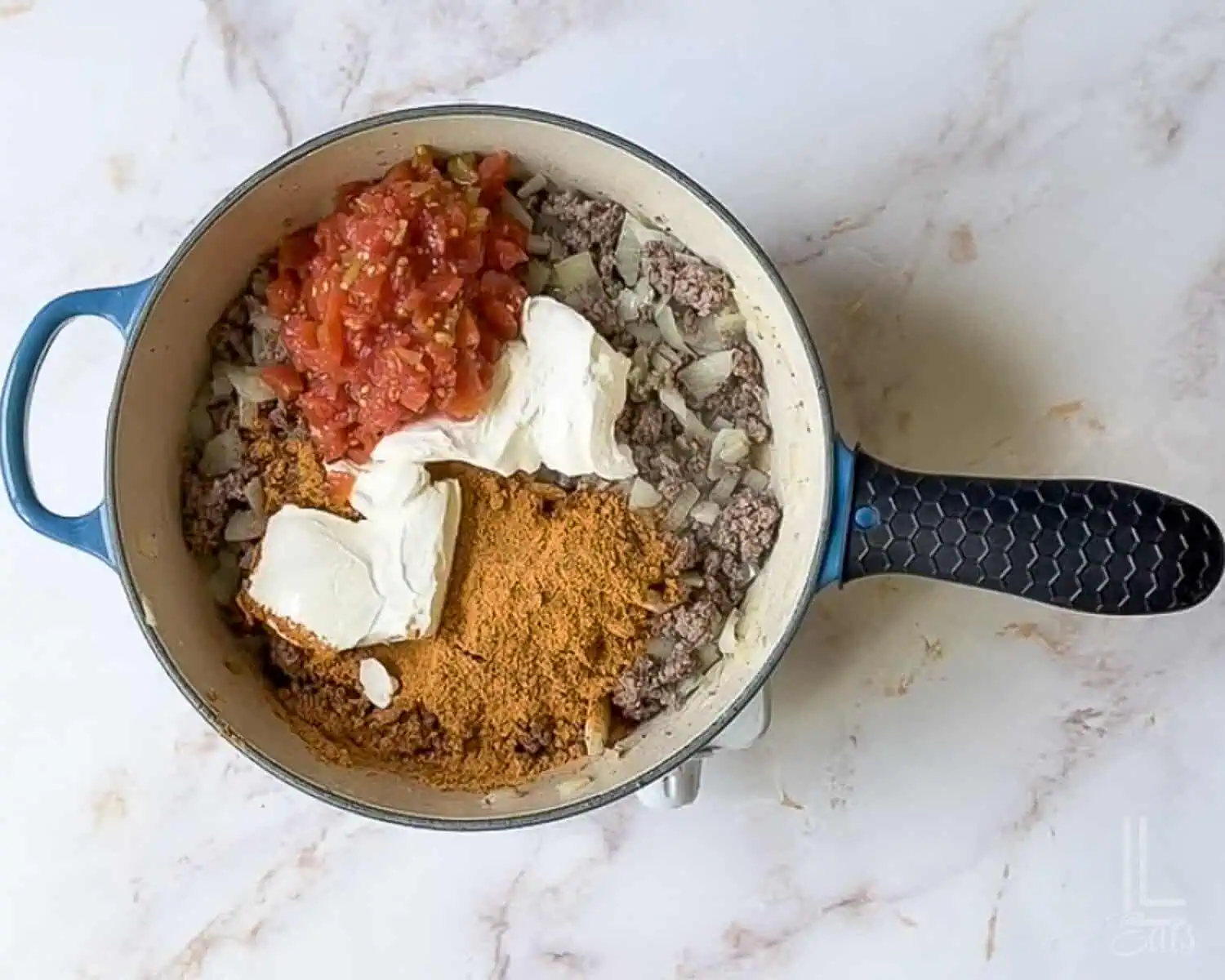 rotel, taco seasoning, and cream cheese added to the ground beef mixture.