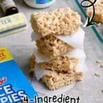 Stacked rice krispie treats with marshmallow fluff on parchment paper.