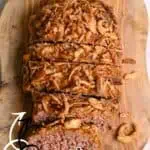 Lamberts Lately Lipton Onion Soup Meatloaf with crispy fried onions on a wooden cutting board.