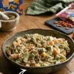 Creamy dill pickle pasta salad with cheese and bacon in a black bowl.