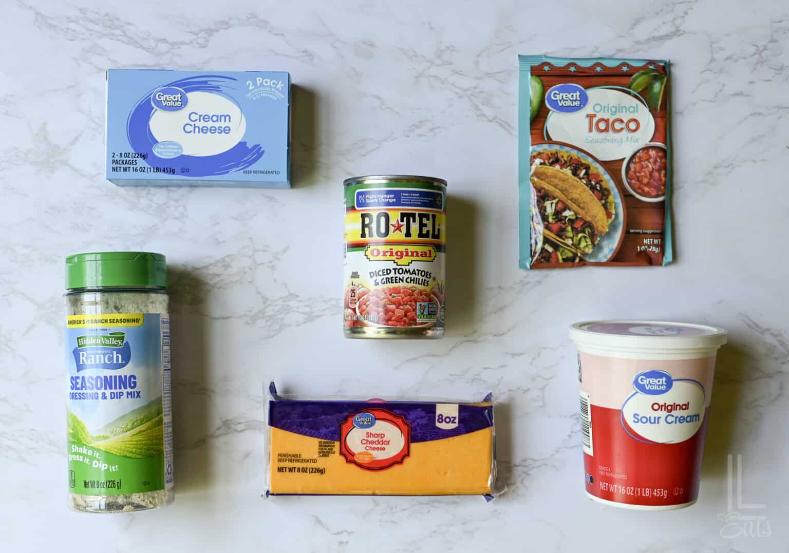 ingredients for boat dip (cream cheese, taco seasoning, cheddar, sour cream, ranch, and rotel).