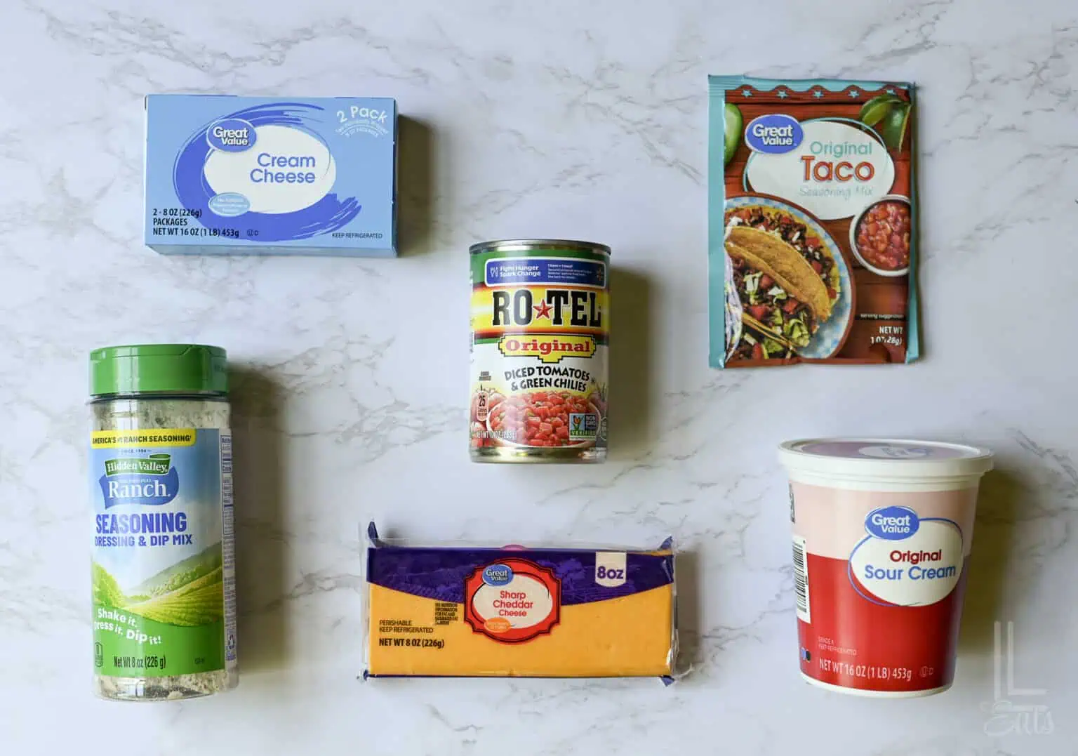 ingredients for boat dip (cream cheese, taco seasoning, cheddar, sour cream, ranch, and rotel).