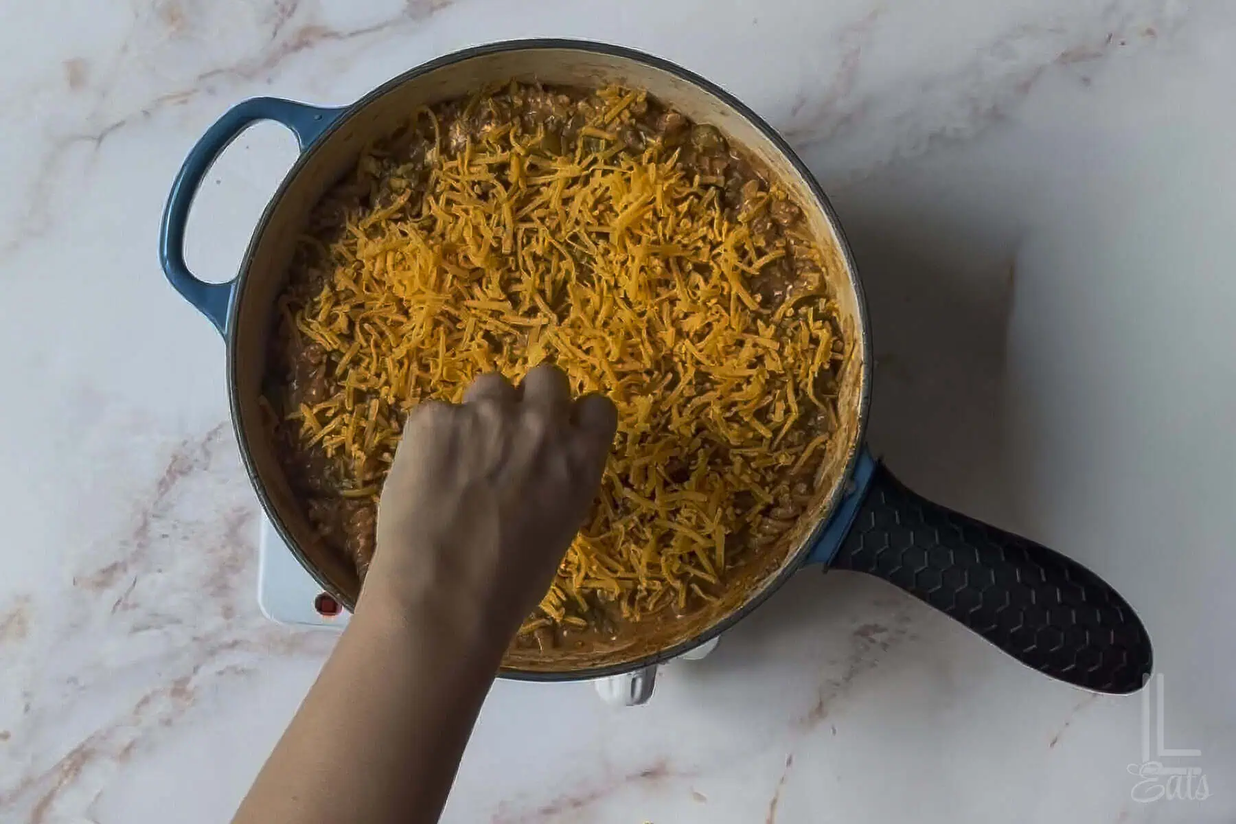 sprinkling shredded cheddar over the cheeseburger pasta.