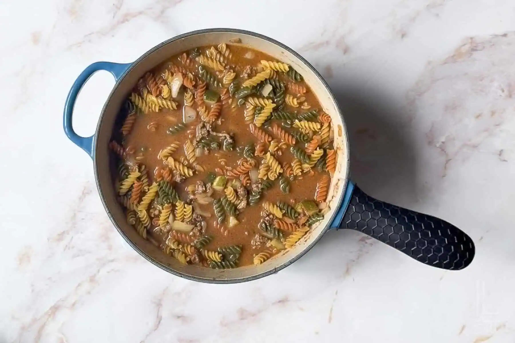 chicken broth and rotini pasta added to the burger sauce mixture.