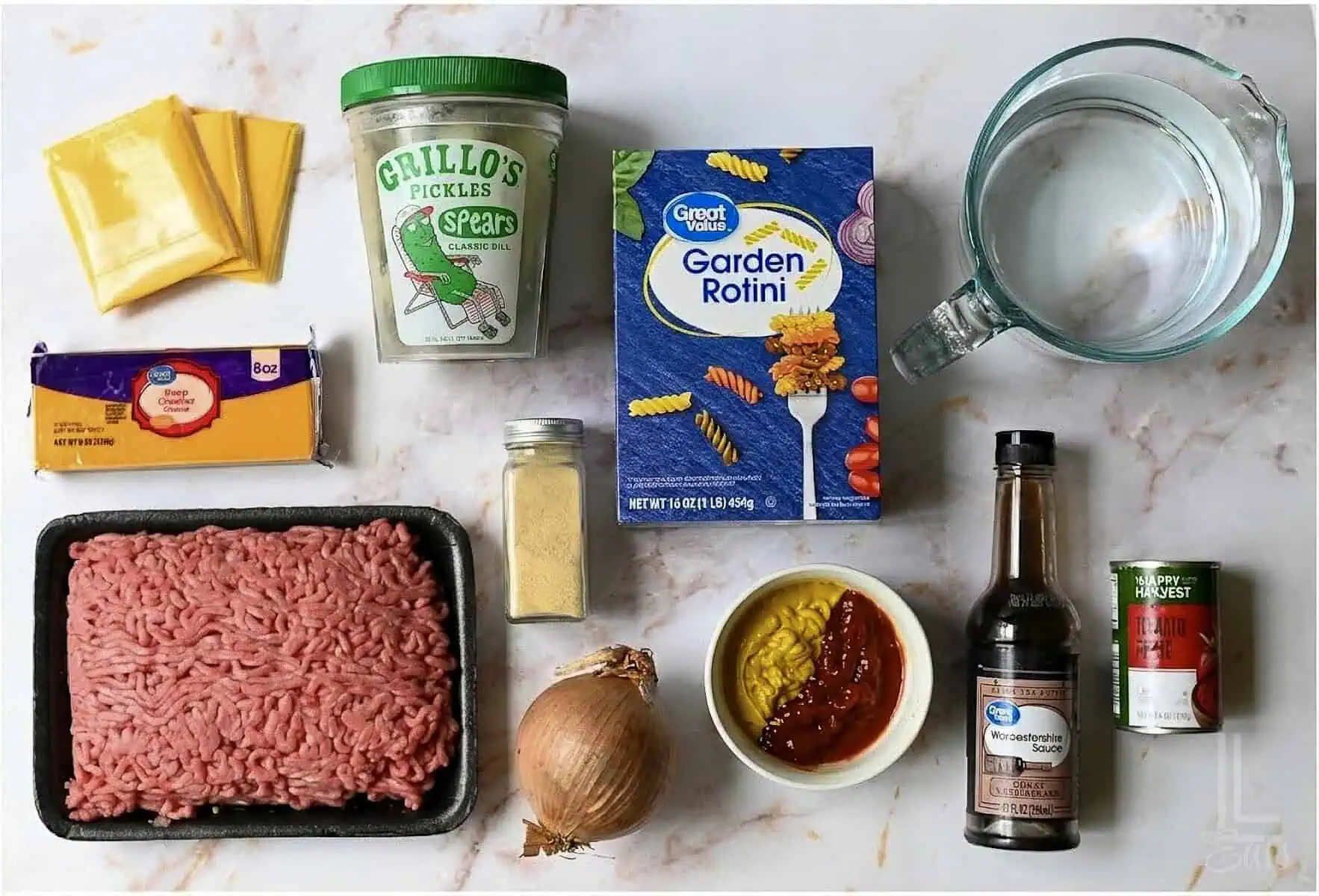 ingredients for one pot cheeseburger pasta, including ground beef, ketchup, mustard, cheddar, and american cheese.