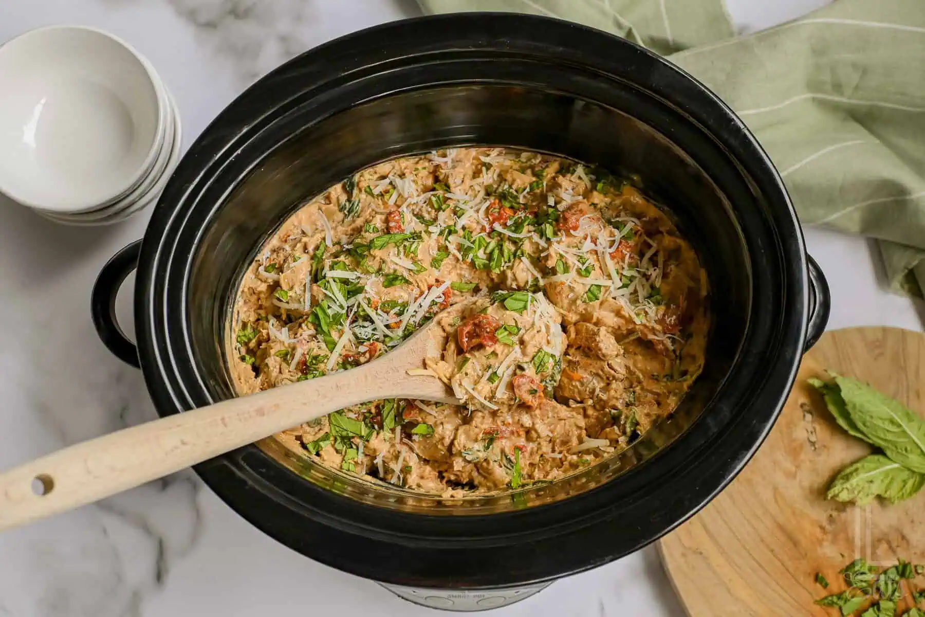 marry me chicken covered in parmesan and basil in a crock pot.