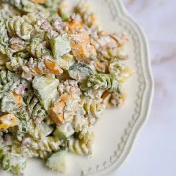 plate of dill pickle pasta salad with cheddar cheese and chopped pickles.