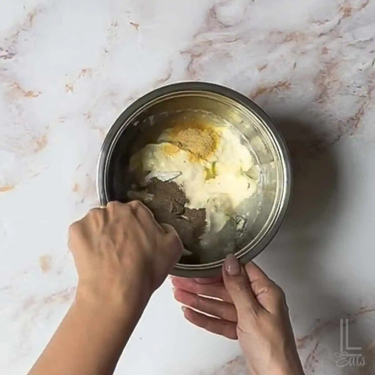 stirring together the ingredients for the creamy pasta salad sauce.