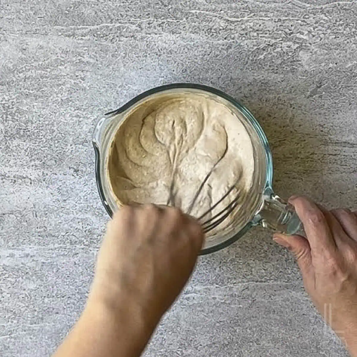 whisking the dressing for the street corn pasta salad in a measuring cup.