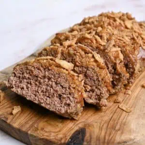 Delicious homemade lipton onion soup meatloaf with crispy topping on wooden cutting board.