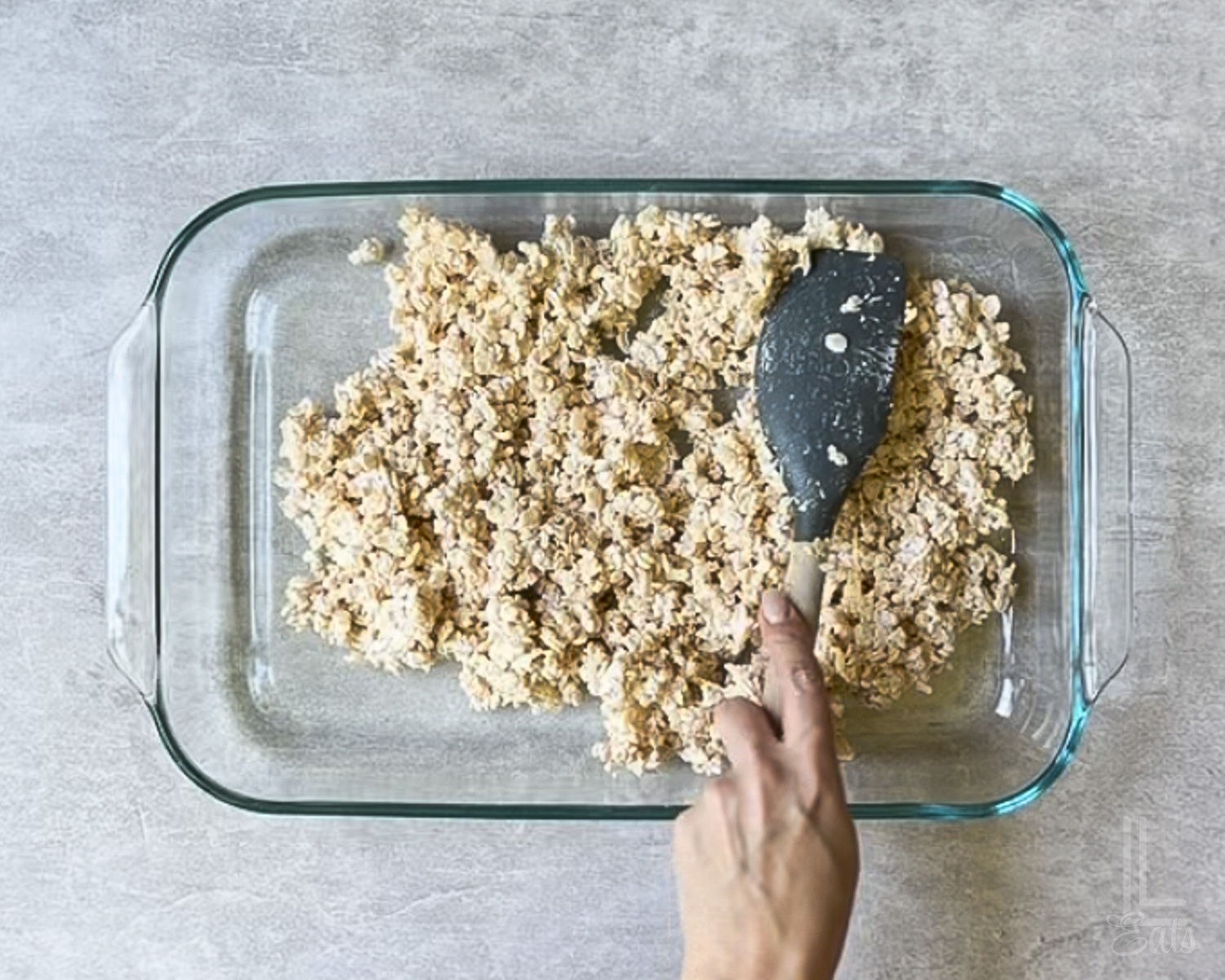 spreading the rice krispies treats mixture into a baking dish.