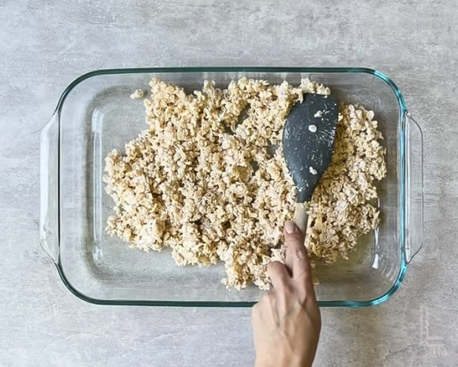 spreading the rice krispies treats mixture into a baking dish.