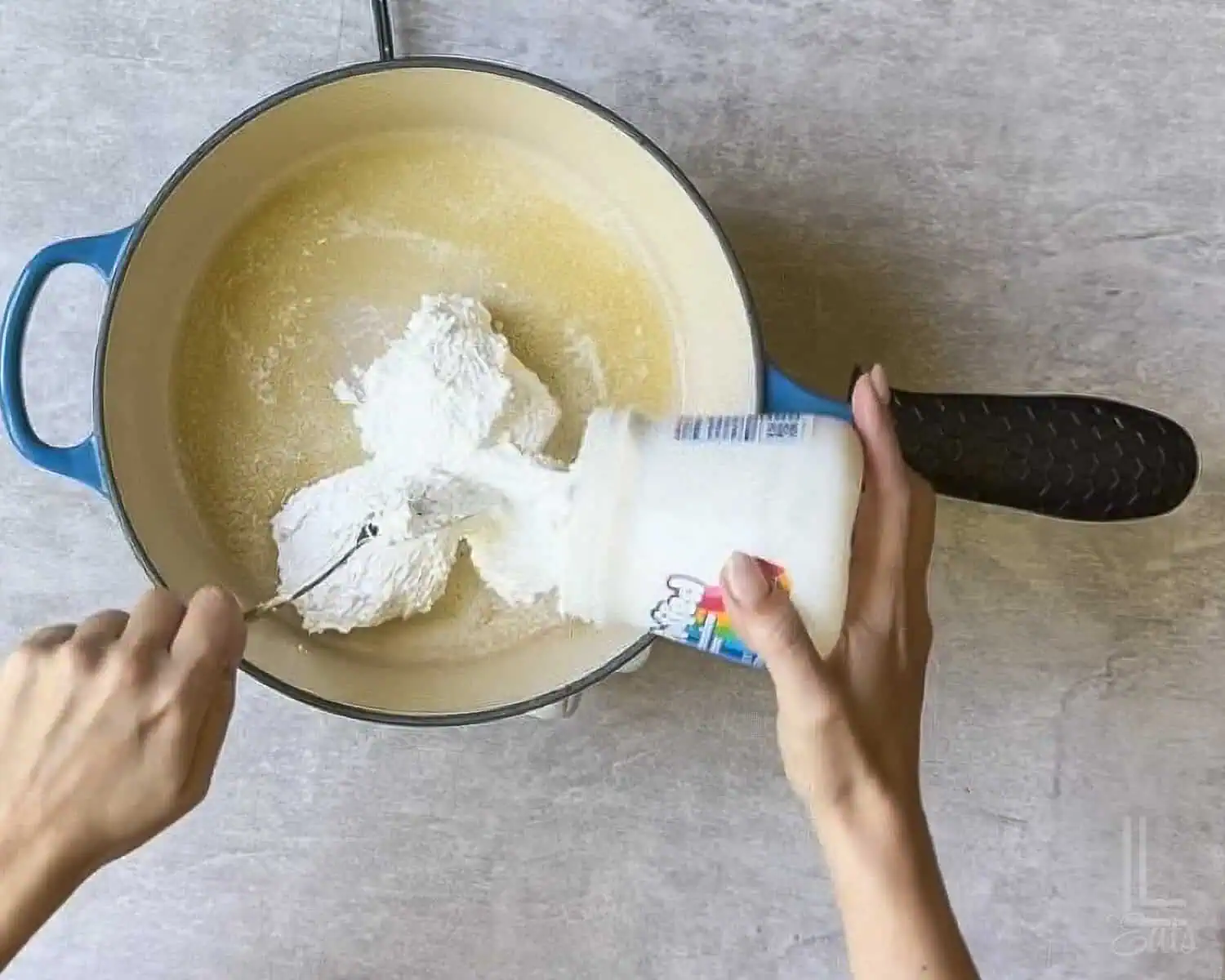 adding marshmallow fluff to melted butter in a pan.