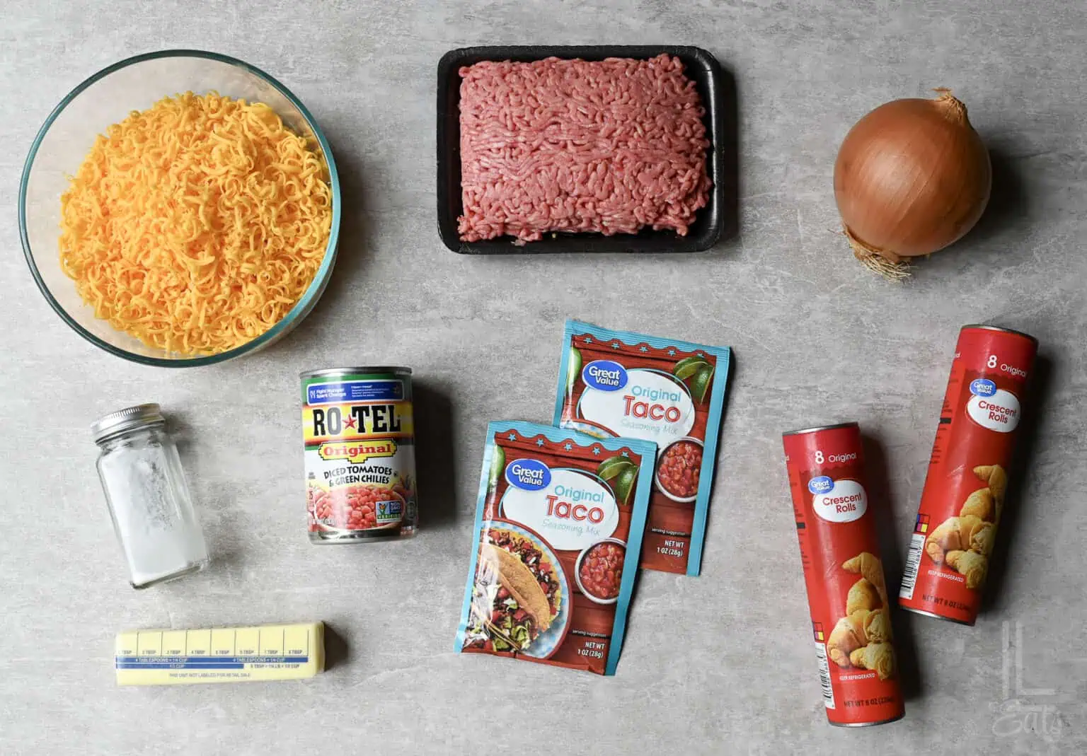 ingredients for a taco crescent ring, including ground beef, cheese, and rotel tomatoes.