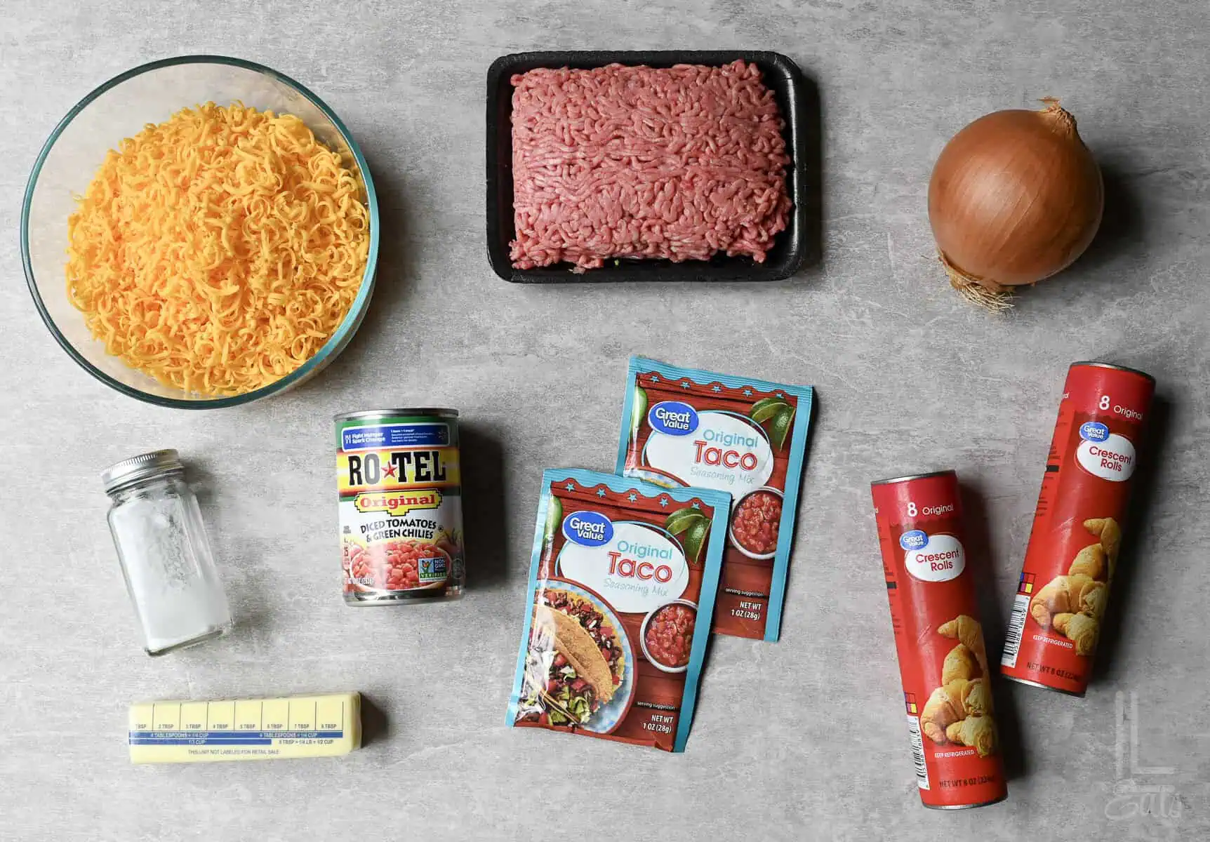 ingredients for a taco crescent ring, including ground beef, cheese, and rotel tomatoes.