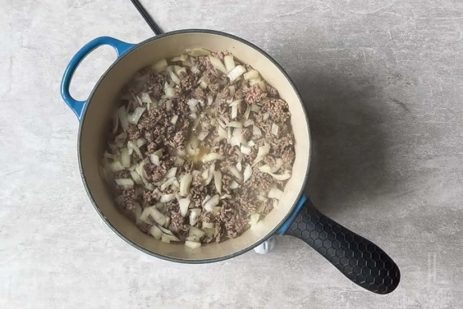 ground beef and onion cooking in a large skillet.