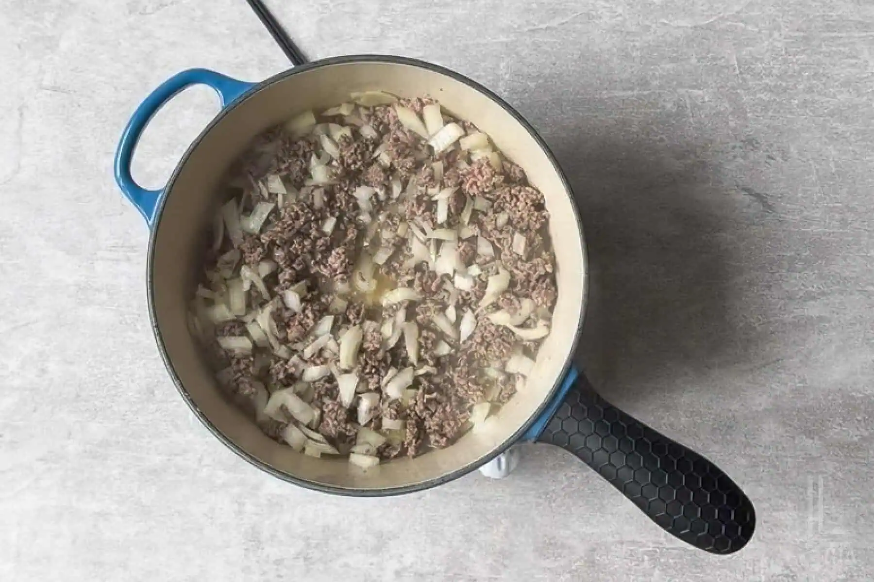 ground beef and onion cooking in a large skillet.