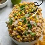 Close-up of Elote Corn Dip with cilantro and corn kernels in a bowl.