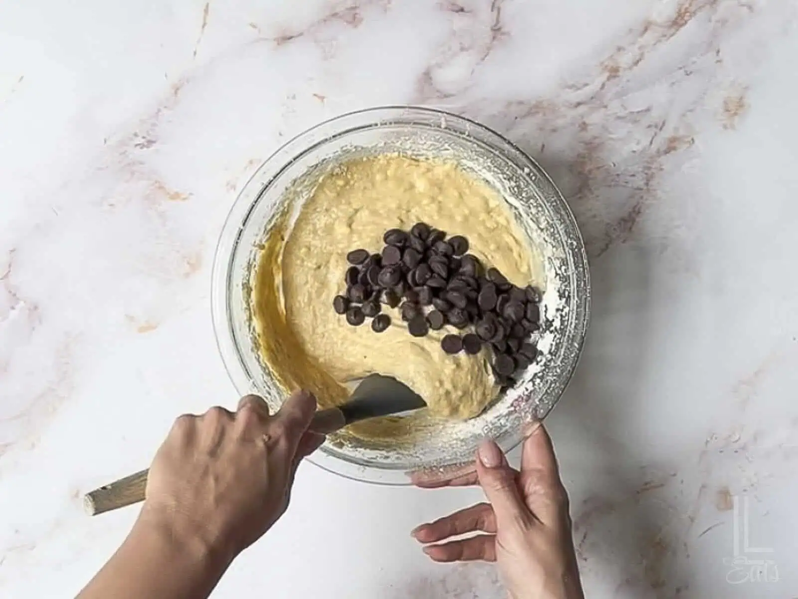 folding chocolate chips into the banana bread batter.