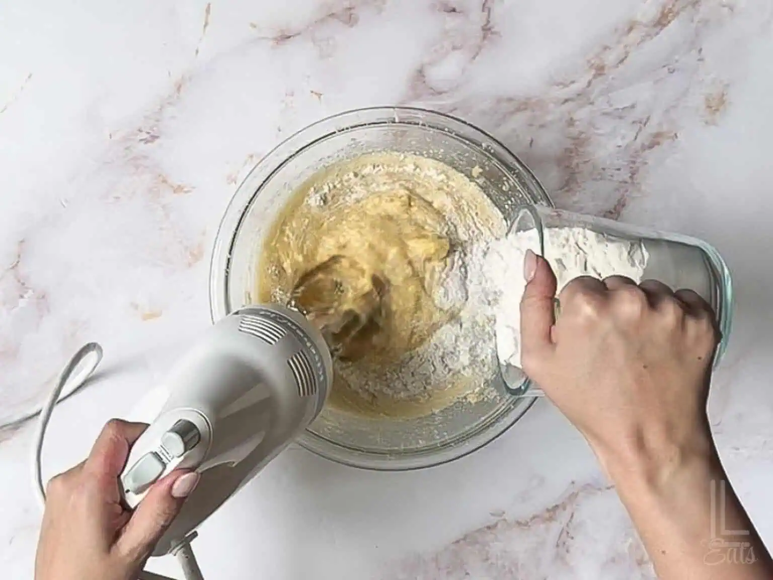 adding the flour mixture into the banana bread batter.