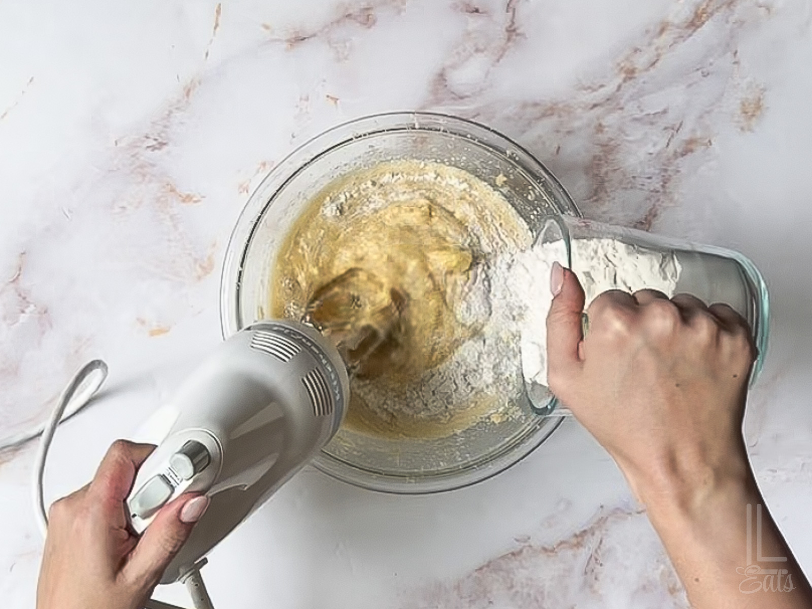 adding the flour mixture into the banana bread batter.