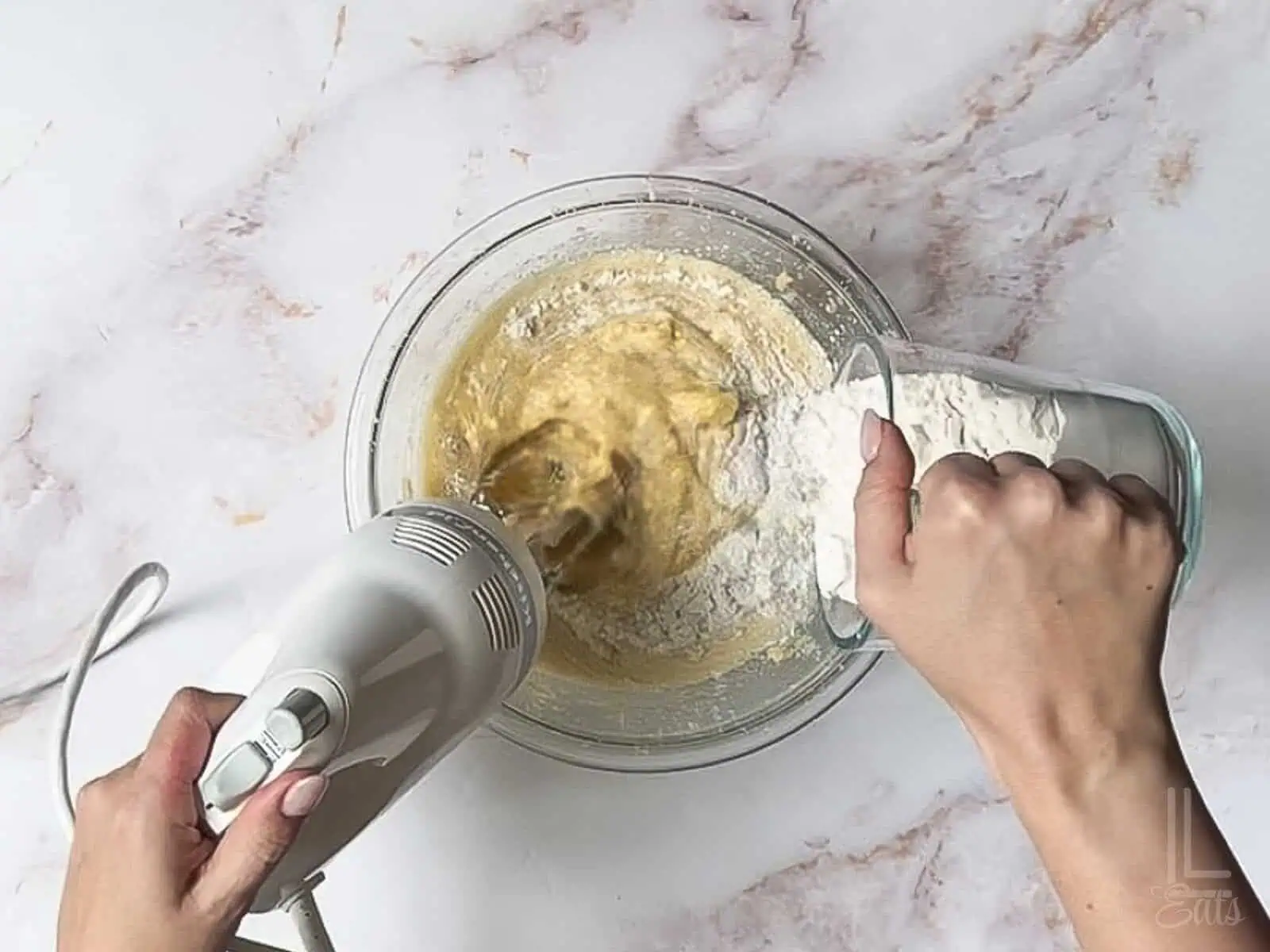 adding the flour mixture into the banana bread batter.