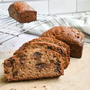 chocolate chip banana bread cut into slices and stacked on a cutting board.