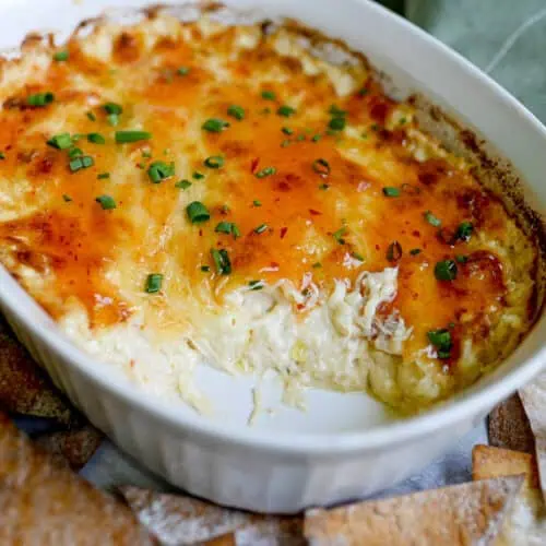crab rangoon dip after baking, covered in a sweet chili sauce and green onions.