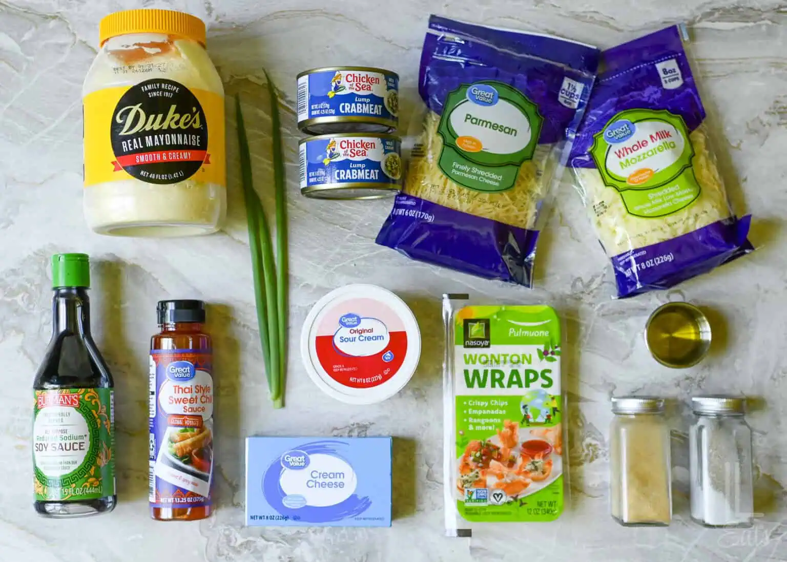 ingredients for crab rangoon dip, including cream cheese, canned crabmeat, and wontons to make chips.