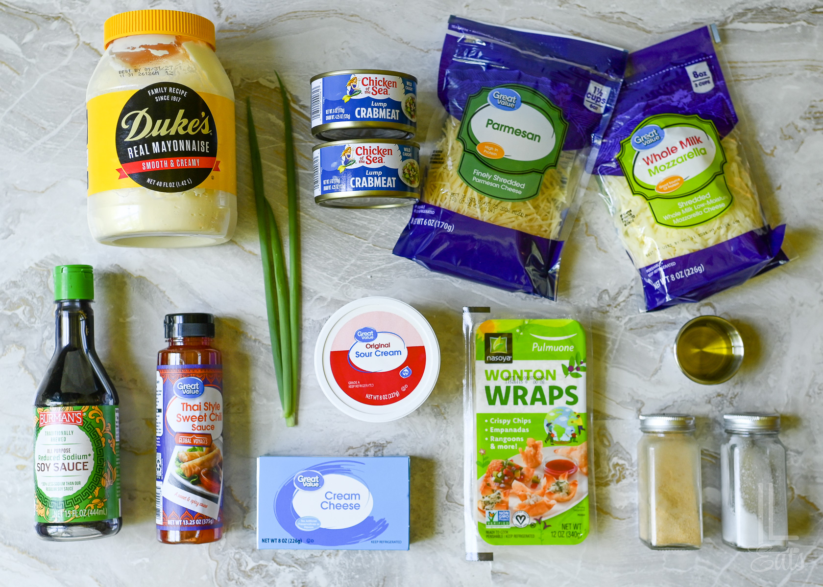 ingredients for crab rangoon dip, including cream cheese, canned crabmeat, and wontons to make chips.