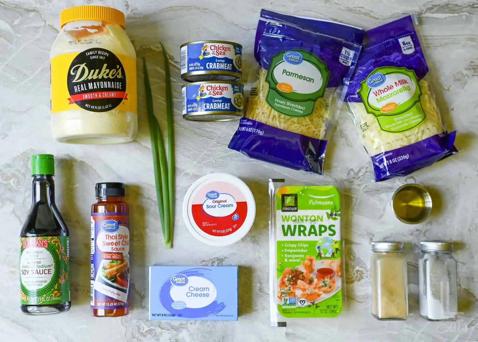 ingredients for crab rangoon dip, including cream cheese, canned crabmeat, and wontons to make chips.