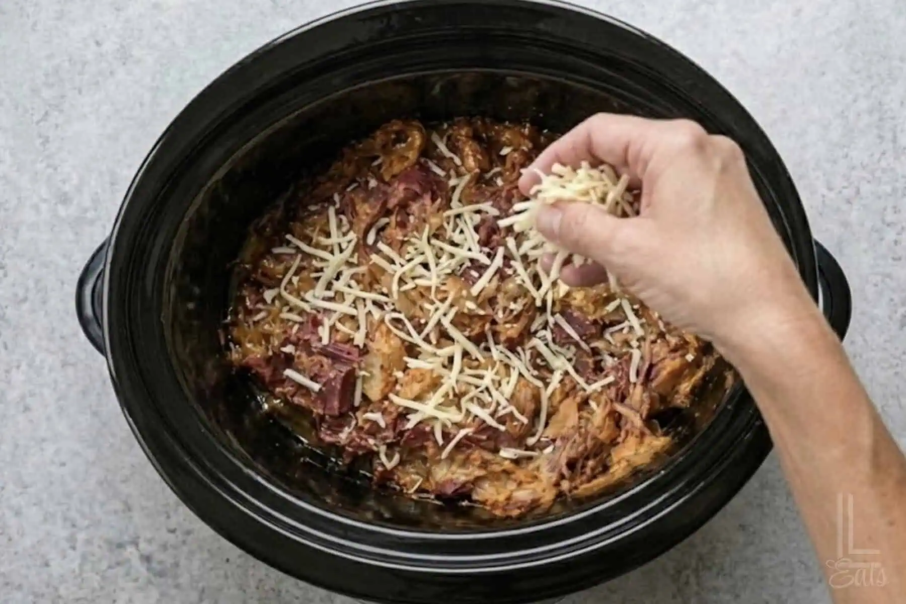 sprinkling shredded swiss cheese over the top of the cooked reuben dip.