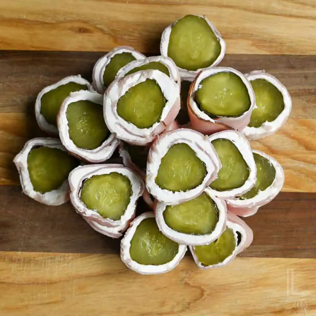 stack of pickle roll ups on a cutting board.