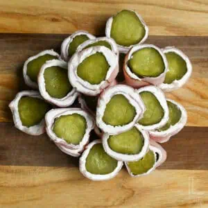 stack of pickle roll ups on a cutting board.