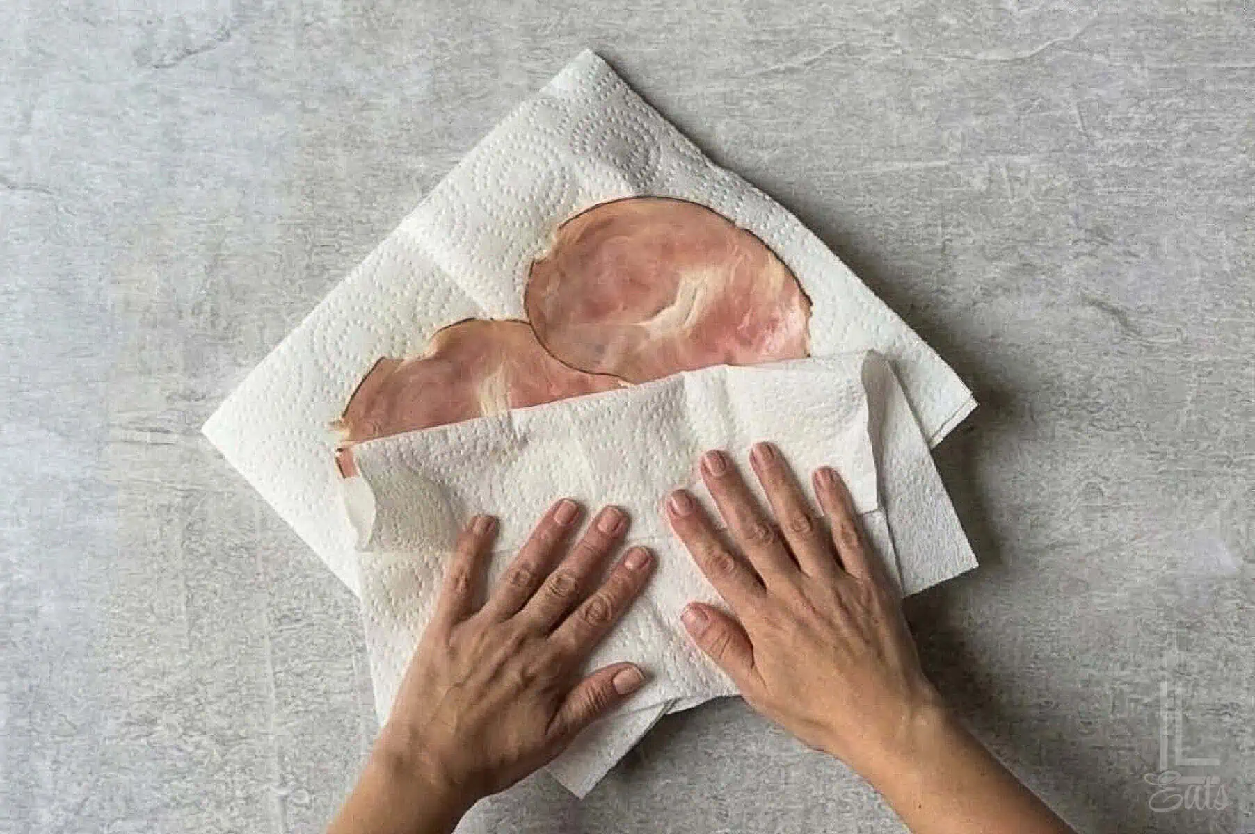 drying ham in between paper towels.