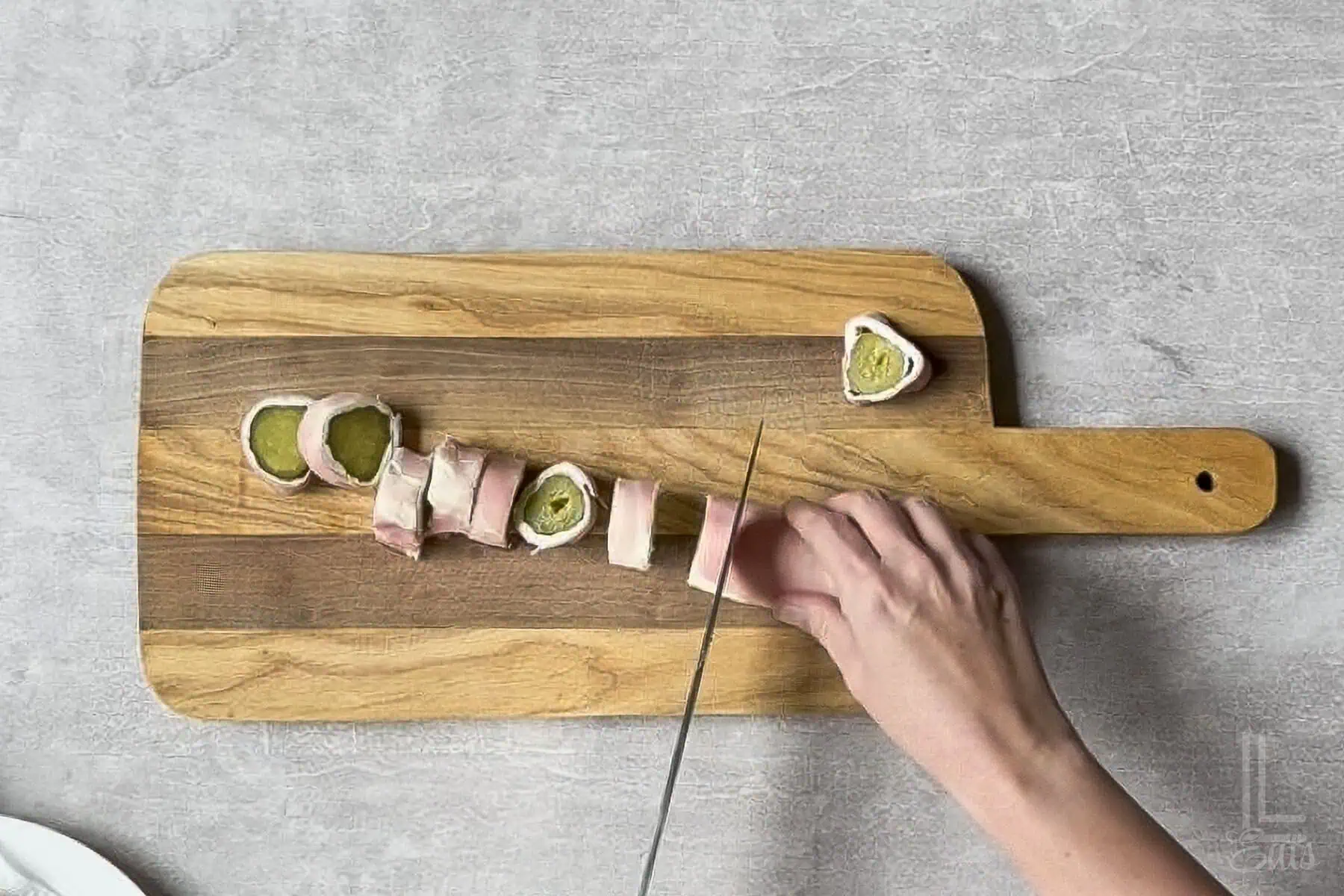 cutting the pickle roll ups with a sharp knife.