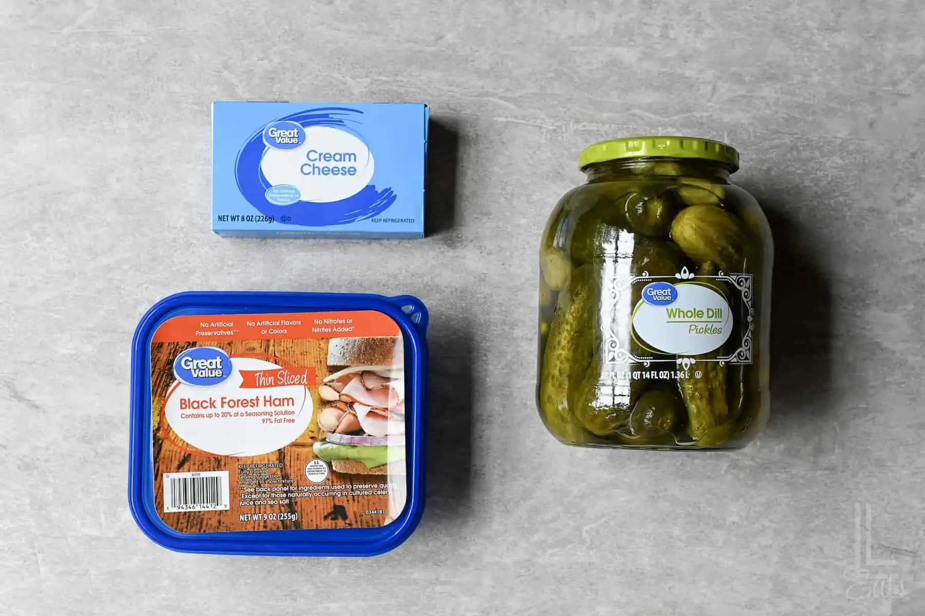 ingredients for pickle roll ups (ham, whole dill pickles, and cream cheese).